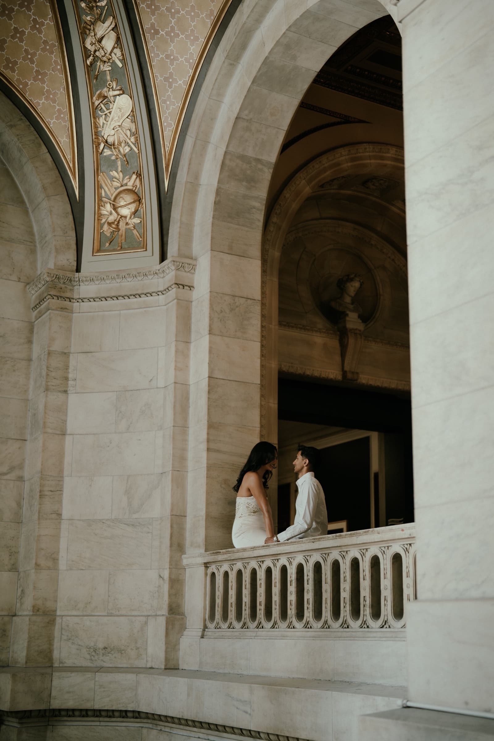 Ananya and Varun together beneath the arches of a marble balcony